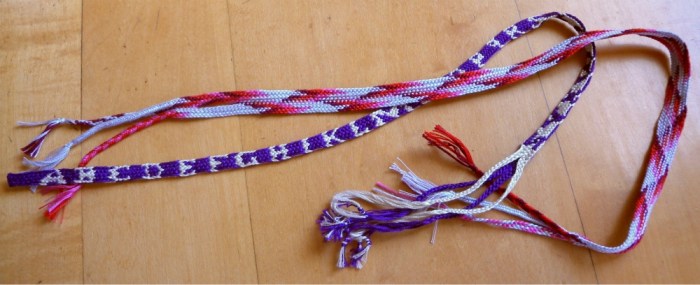 Nun's Book letterbraid (double weave with complementary pick-up between 2 plain weave layers); and wider single-layer plain weave braid. 10-loop Spanish braids, by loopbraider.com