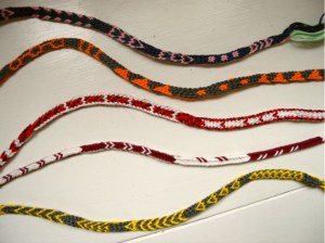 various fingerloop braided braids with pickup-type patterning, made by Ingrid Crickmore